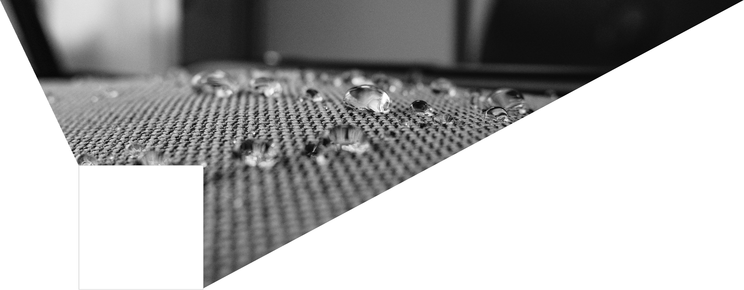 Druppels water liggend op textiele ondergrond. Ook wel pareleffect genoemd.